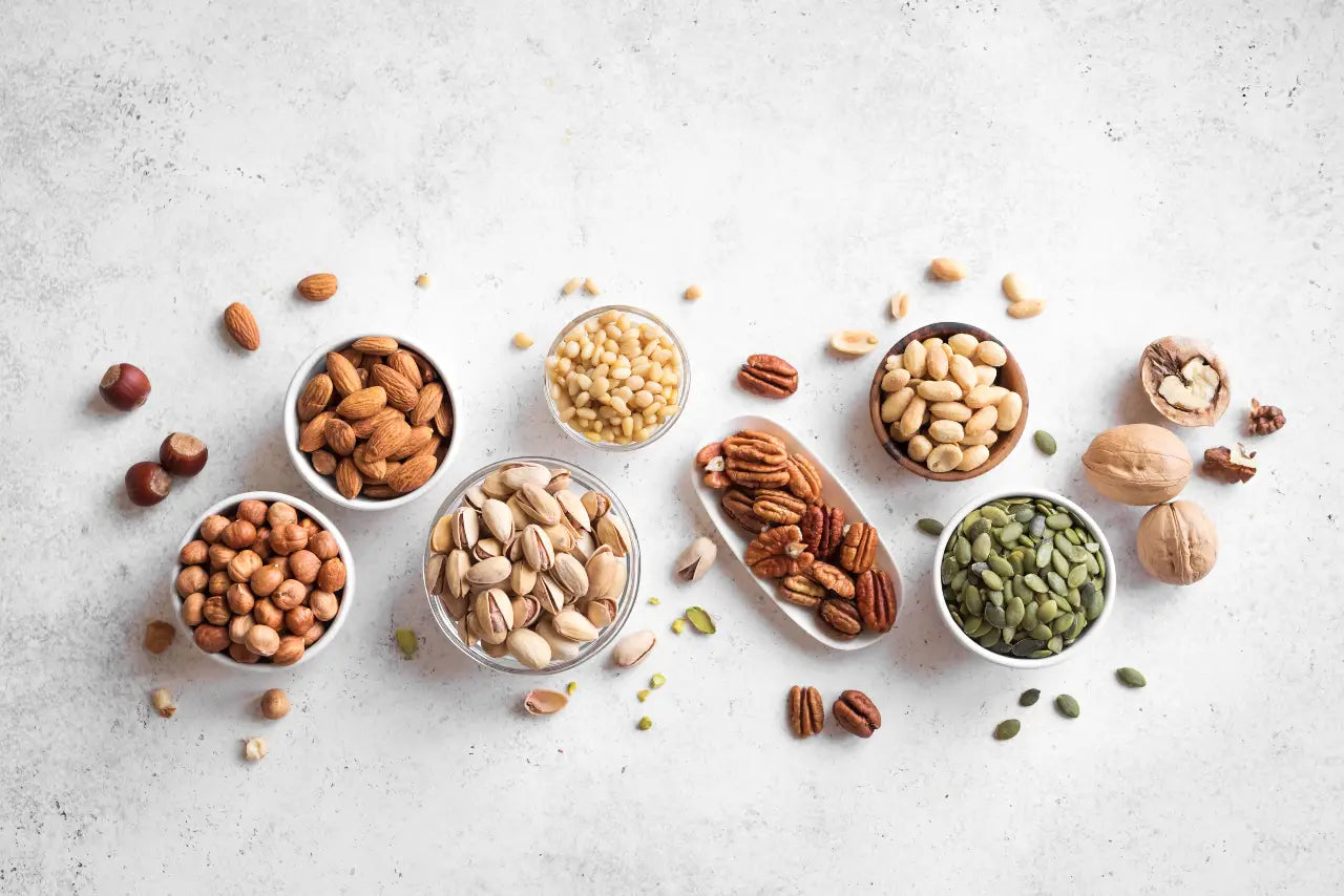 A selection on bowls of activated nuts on a white background