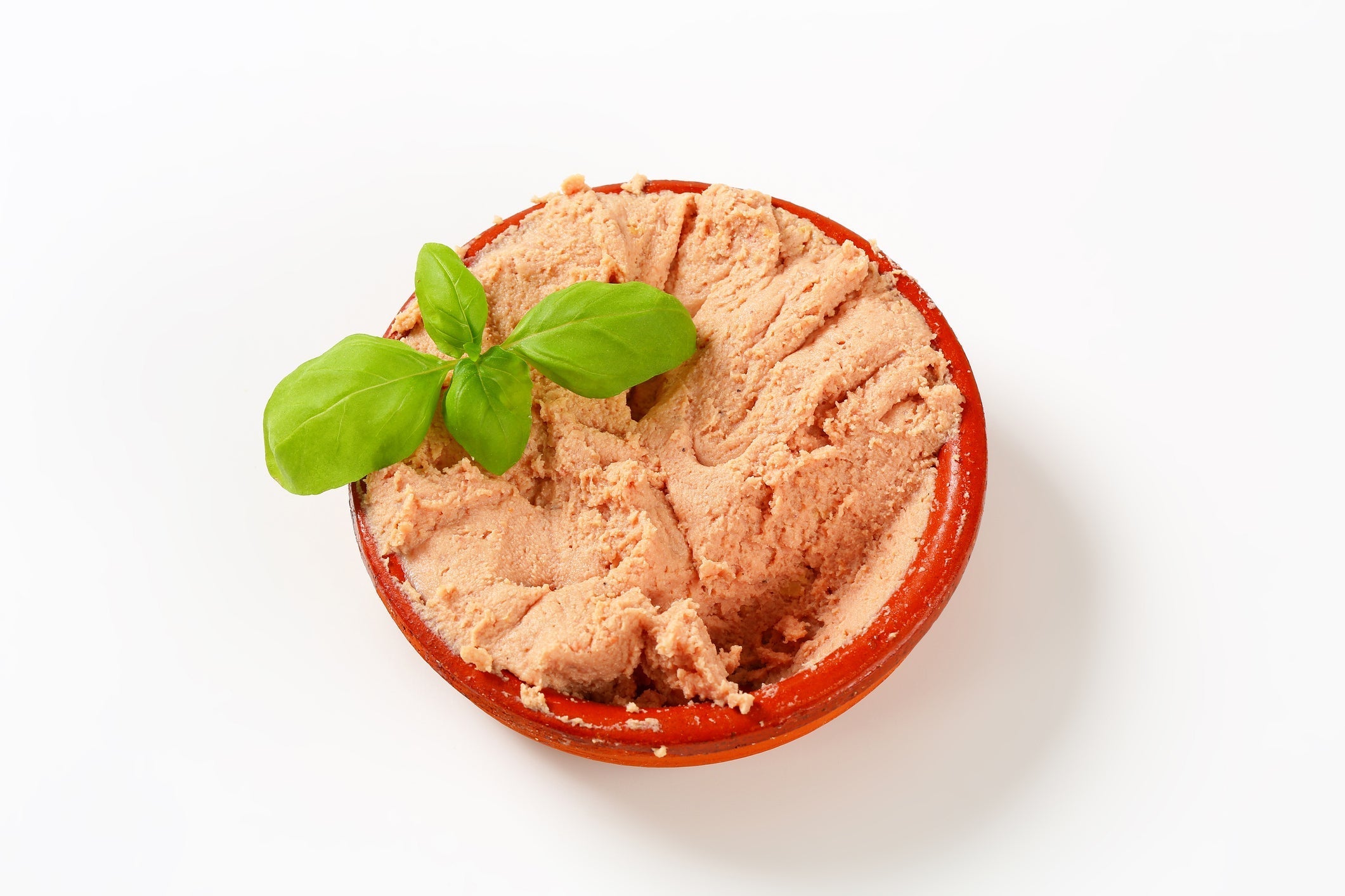 chicken liver pate in a red dish on a white background